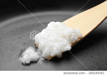 Frying pan with coconut oil and wooden spatula, closeup. Healthy cooking Frying pan with coconut oil and wooden spatula, closeup. Healthy cooking 100289361