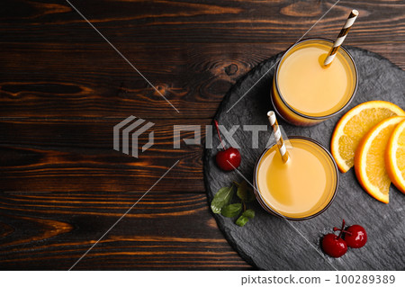 Fresh alcoholic Tequila Sunrise cocktail on wooden table, top view. Space for text 100289389