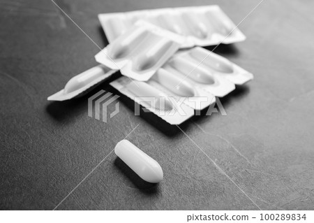 Suppositories on grey stone table. Hemorrhoid treatment Suppositories on grey stone table. Hemorrhoid treatment 100289834