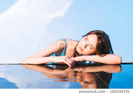 Beauty portrait with water of young woman fashion model with dark long hair on blue background 100294702