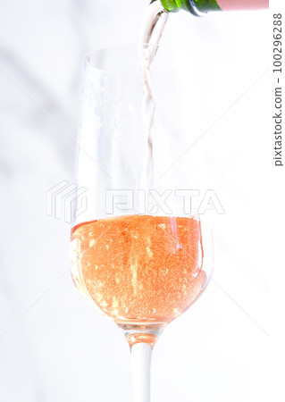 Pour well-chilled rosé champagne (sparkling wine) into a flute glass Pour well-chilled rosé champagne (sparkling wine) into a flute glass 100296288