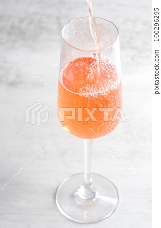 Pour well-chilled rosé champagne (sparkling wine) into a flute glass 100296295