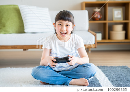 Elementary school girl playing games in the living room 100296865