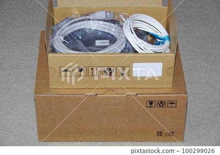 打開一箱從電話公司送到家裡的光線路設備的圖片 100299026