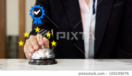 Businesswoman hand ringing silver service bell on hotel reception desk, shows the sign of the top service Quality assurance 5 star, Guarantee, Standards, ISO certification and standardization concept Businesswoman hand ringing silver service bell on hotel reception desk, shows the sign of the top service Quality assurance 5 star, Guarantee, Standards, ISO certification and standardization concept 100299076
