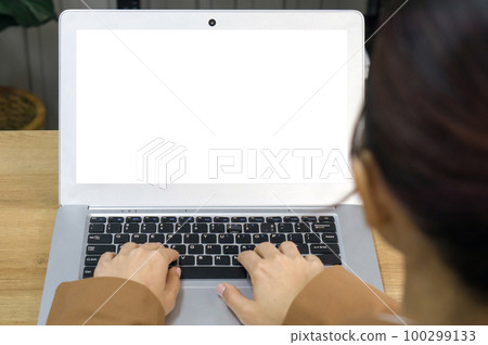 Back view of businesswoman in brown suit sit at desk in office typing on laptop computer keyboard with white screen. Back view of businesswoman in brown suit sit at desk in office typing on laptop computer keyboard with white screen. 100299133