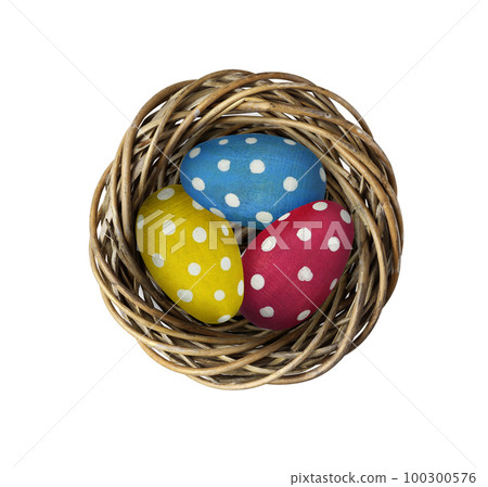 Wooden painted eggs in a twisted round nest isolated on white background. Easter concept. Wooden painted eggs in a twisted round nest isolated on white background. Easter concept. 100300576