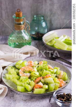 Fresh salad of celery and shrimp on a plate for a vegetarian diet vertical view 100302351