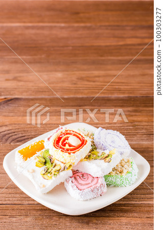 Traditional Turkish Delight on a plate on a wooden table 100303277