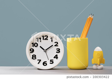 Plain clock and stationery on pastel blue background desk. Ten o'clock. copy space, time management or business concept. Opening or closing hours. Schedule or working hours. daylight saving time 100303422