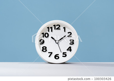 Plain wall clock on pastel blue background desk. Ten o'clock. copy space, time management or business concept. Opening or closing hours. Schedule or working hours. daylight saving time 100303426