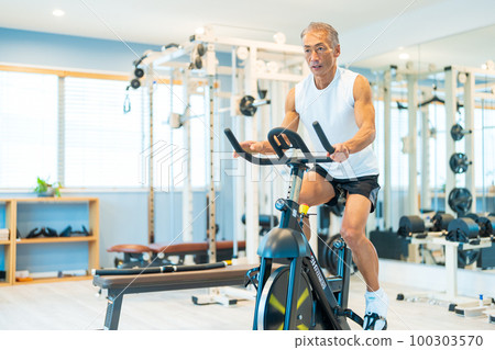 中間人在健身房騎健身車 100303570