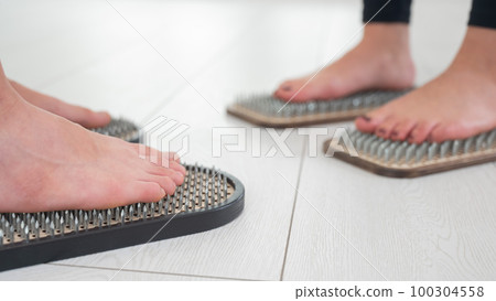 Caucasian and Asian women stand up sadhu boards together.  100304558