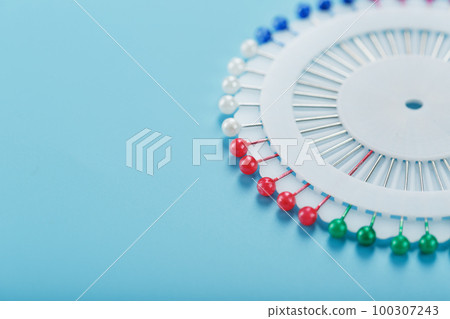 A set of multicolored needles pins in a round platform 100307243