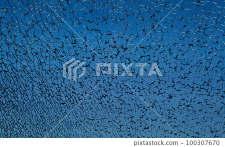 Dark blue broken cracked shattered window glass with black cracks 100307670