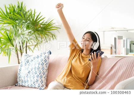 Asian teenager listening to music on smartphone with headset enjoy. Asian teenager listening to music on smartphone with headset enjoy. 100308463
