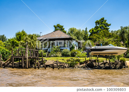 Boat tour on the Parana Delta, Tigre, Buenos Aires, Argentina. Palm trees, construction site of modern brick house. 100309803
