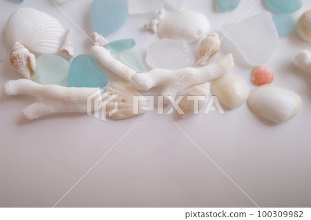 Blue sea glass and shells arranged in the upper half 100309982