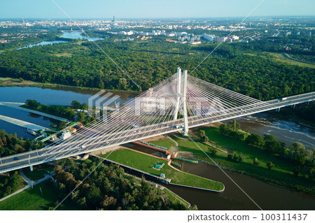 Aerial drone view of Redzinski bridge over Odra river in Wroclaw city, Poland. Large cable stayed bridge with car traffic in european city, bird eye view. Transportation infrastructure and logistic 100311437