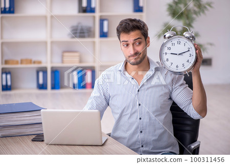 Young male employee in time management concept Young male employee in time management concept 100311456