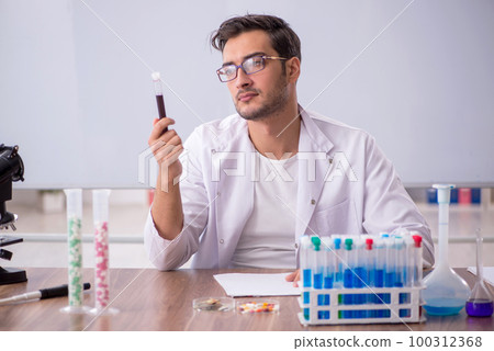 Young male chemist in front of white board Young male chemist in front of white board 100312368