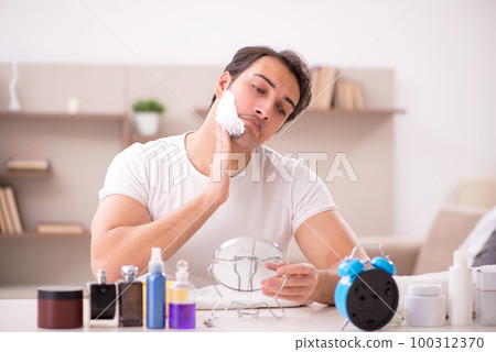 Young man shaving face at home Young man shaving face at home 100312370