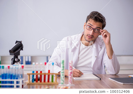 Young male chemist in front of white board Young male chemist in front of white board 100312406