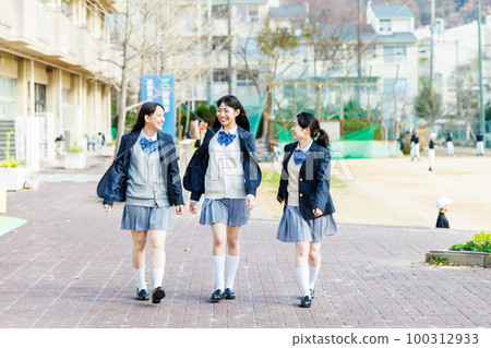 A high school girl who walks while talking with friends on campus 100312933