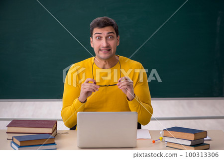 Young male student sitting in the classroom 100313306