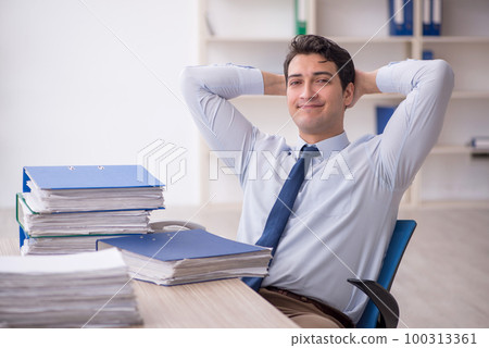 Young male employee and too much work in the office 100313361