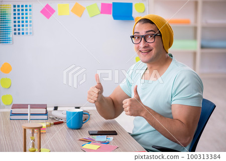 Young male designer sitting in the office Young male designer sitting in the office 100313384
