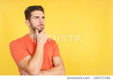 Caucasian man with hand on face and thoughtful expression Caucasian man with hand on face and thoughtful expression 100313388