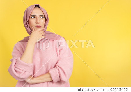 Muslim woman with hand on face and thoughtful expression 100313422