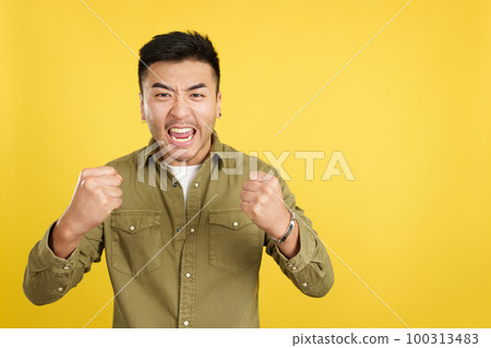 Excited chinese man celebrating while raising arms Excited chinese man celebrating while raising arms 100313483