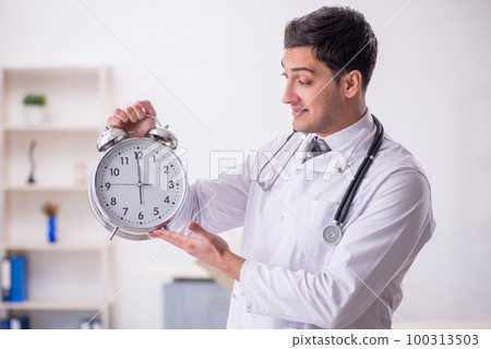 Young male doctor in time management concept Young male doctor in time management concept 100313503