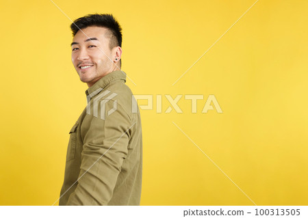 Happy chinese man turning to smile at the camera 100313505