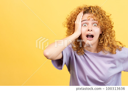 Woman with hand on head expressing dismay 100313636