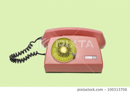 Playful retro phone with a disc of fruit kiwi. 100313708