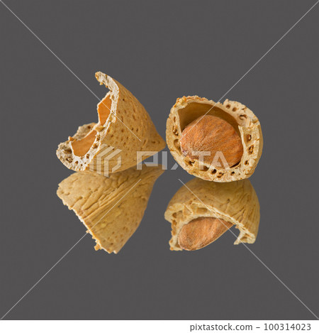 Almond nut in a shell cracked in half Almond nut in a shell cracked in half 100314023