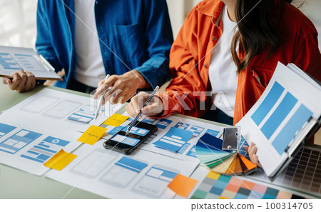 Asian businessman and woman people meeting in office. Employee brainstorm and work as team, plan and discuss project by point on paper and tablet. 100314705
