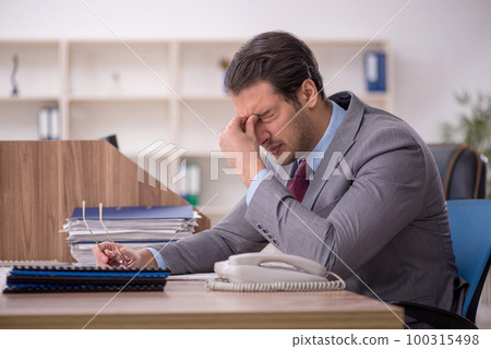 Young male employee working in the office Young male employee working in the office 100315498