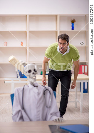 Young male patient visiting skeleton doctor 100317241