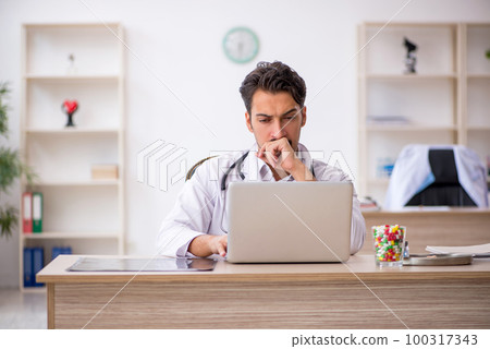 Young male doctor working in the clinic Young male doctor working in the clinic 100317343