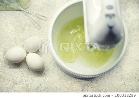 The process of whipping egg whites with a hand mixer. Process of making biscuit. Homemade cakes The process of whipping egg whites with a hand mixer. Process of making biscuit. Homemade cakes 100318289