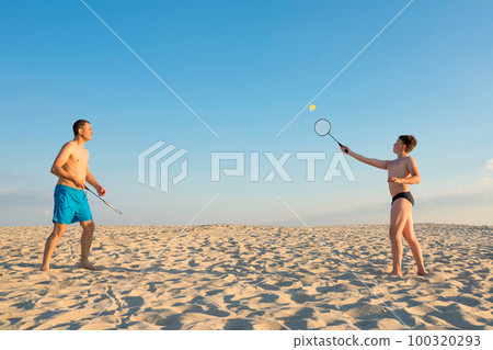 The family plays beach badminton. Sports, lifestyle. Family games in summer on vacation The family plays beach badminton. Sports, lifestyle. Family games in summer on vacation 100320293