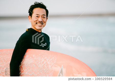 A man in his 50s with a surfboard 100320564