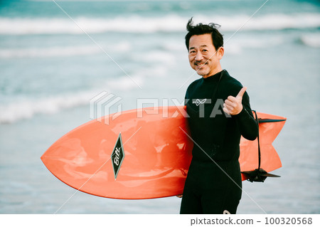 A man in his 50s with a surfboard A man in his 50s with a surfboard 100320568