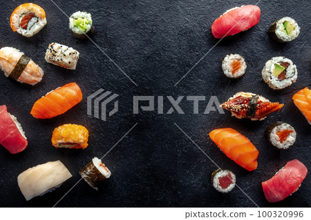 Sushi frame, overhead flat lay shot. Rolls, maki, nigiri on a black background 100320996