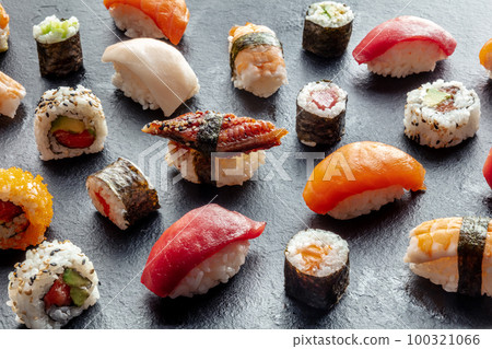 Sushi assortment. Rolls, maki, nigiri on a black background, Japanese food Sushi assortment. Rolls, maki, nigiri on a black background, Japanese food 100321066