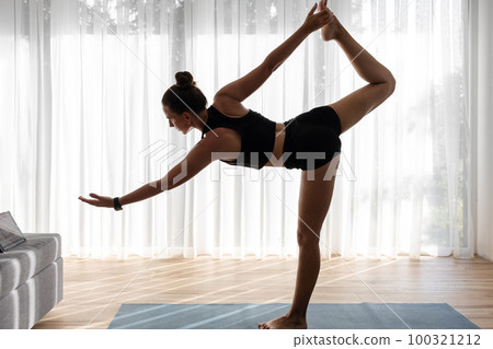 Young woman doing her morning yoga routine at home 100321212